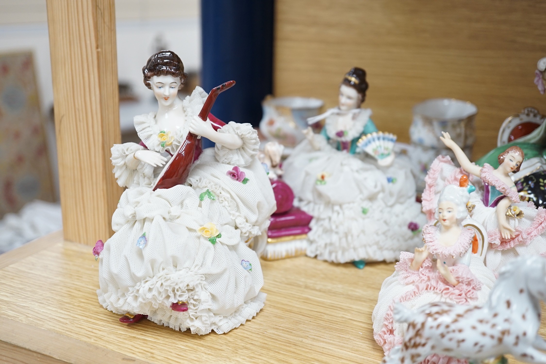 A group of Continental porcelain cabinet cups and saucers, a vase, crinoline figures and a Meissen horse, horse 9 cms high